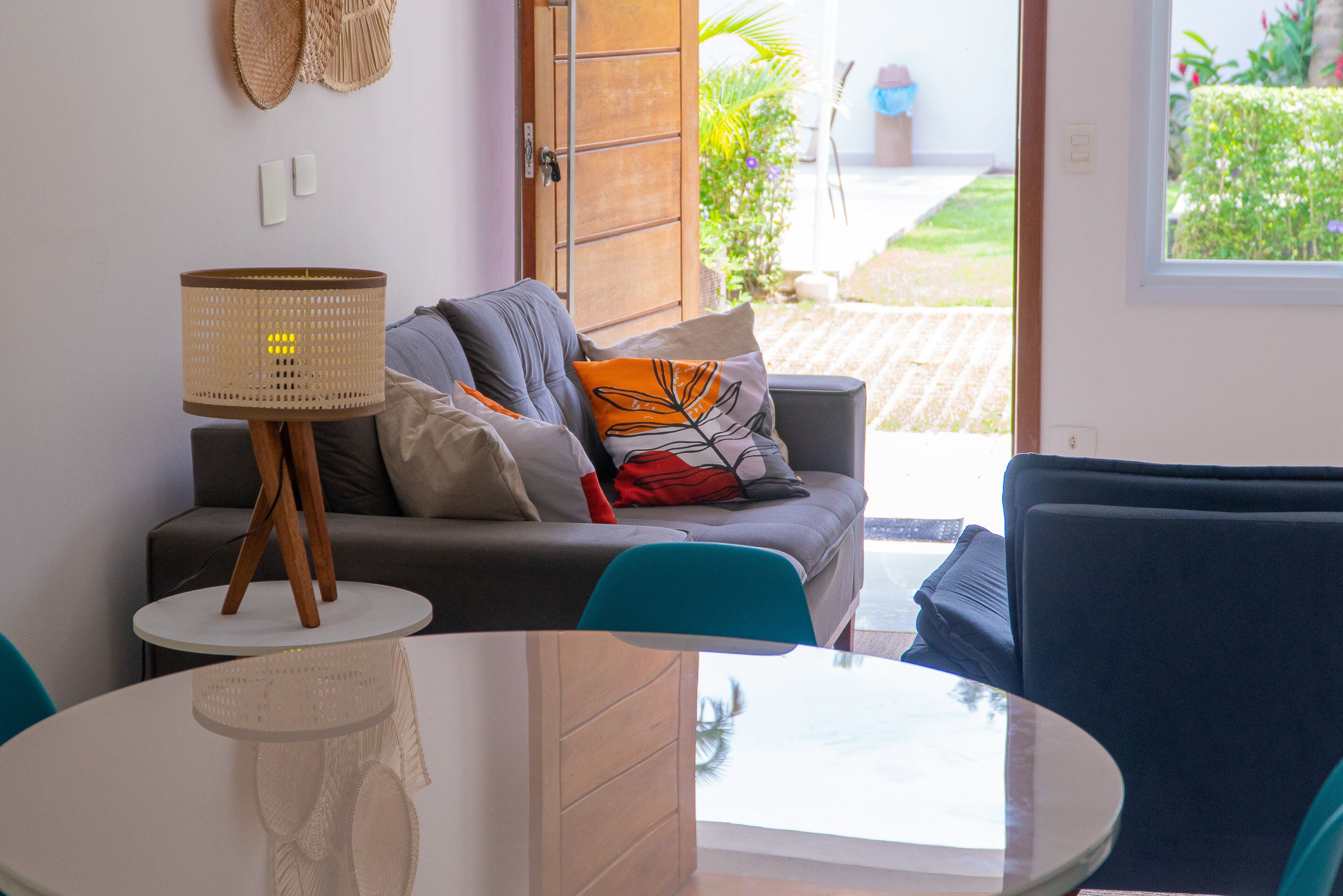 Una sala de estar moderna con un sofá gris, una mesa redonda y una silla azul.