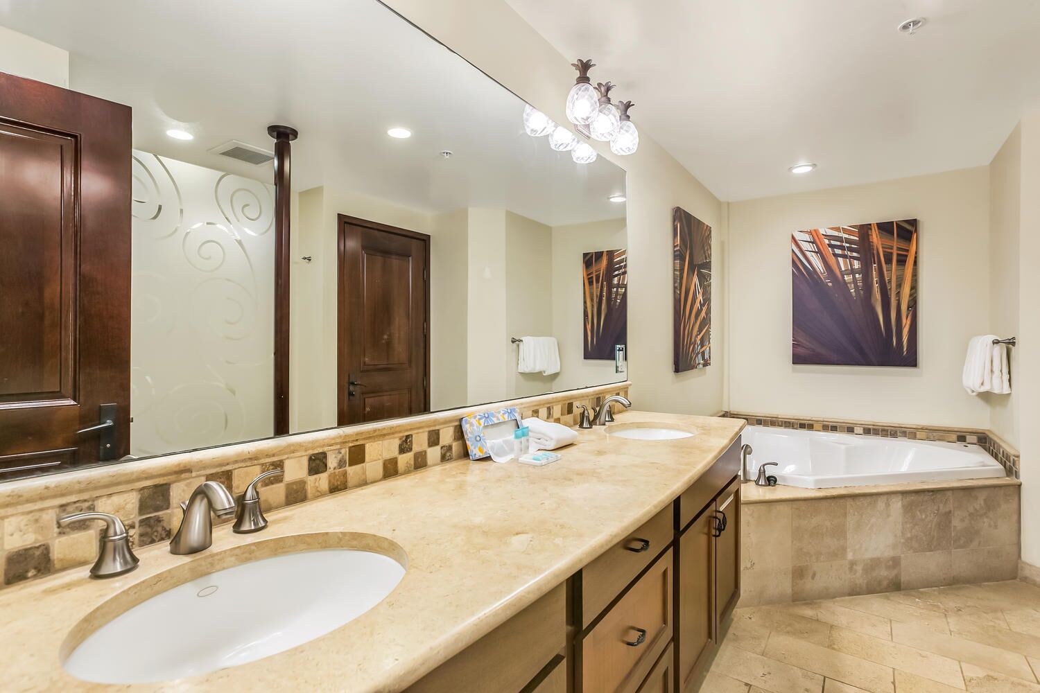 A bathroom with two sinks, a bathtub, and a large mirror.