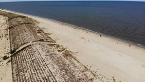 Oversigtsbillede af en strand med sandet bredde og en klar himmel.