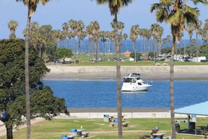 A boat on a calm body of water with palm trees and a beach in the background. - This studio is a 0 bedroom(s), 1 bathrooms, located in San Diego, CA. (San Diego)