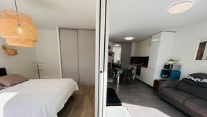 Un dormitorio moderno con cama, mesita de noche y lámpara colgante.