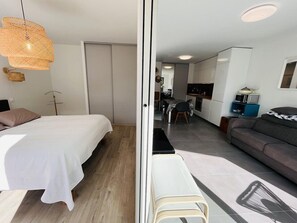 Una camera da letto moderna con un letto, un comodino e una lampada a sospensione.