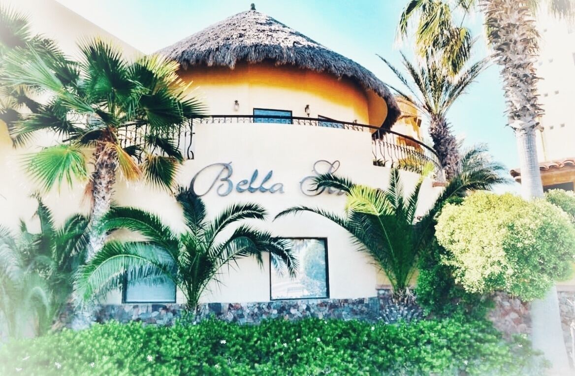 A building with a thatched roof and the name "Bella" on the facade.