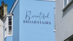 Um edifício com uma placa que diz 'Beautiful BROAD STAIRS'.
