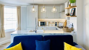 Uma cozinha moderna com bancada de mármore, luminárias pendentes e uma ilha planejada.