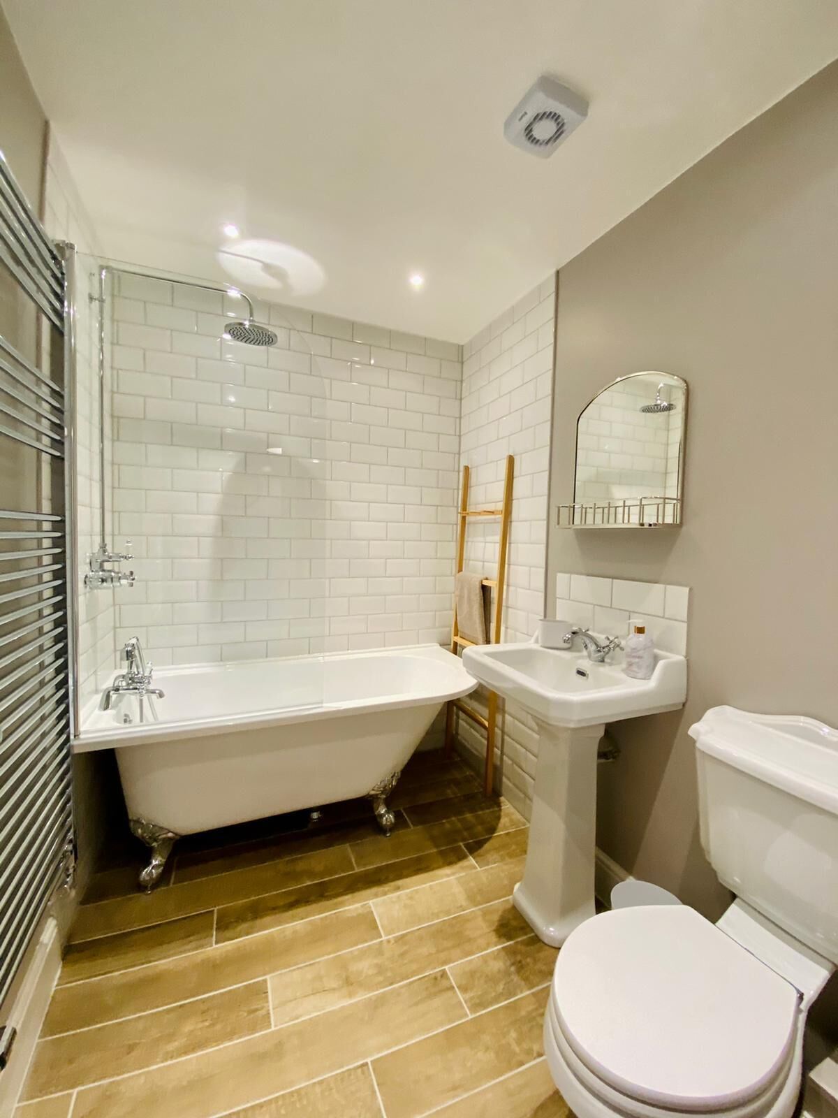 A bathroom with a freestanding bathtub, a pedestal sink, and a toilet.