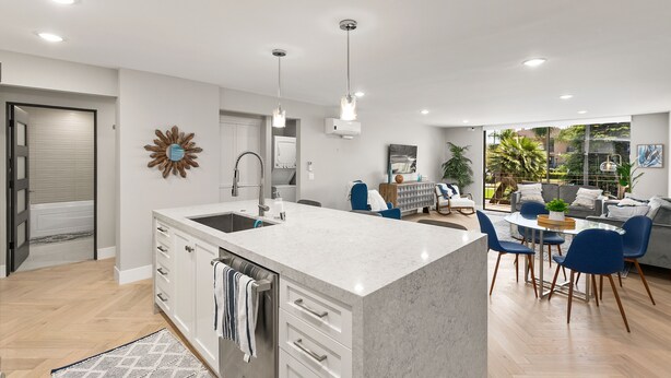 A modern kitchen with a central island, white cabinetry, and a dining area with blue chairs and a round table. - Updated 3-Bedroom Getaway in Coronado Village (Coronado)