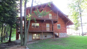 A log cabin with a balcony, surrounded by trees. - Maple Lane Lake House (Tustin)