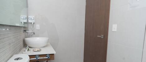 A compact bathroom with a white sink, mirror, and toilet.