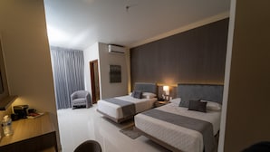 Een hotelkamer met twee bedden, een bureau, een stoel en een badkamer.