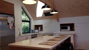 Una cocina moderna con una isla grande, electrodomésticos de acero inoxidable e iluminación colgante.
