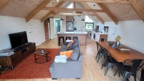 Un moderno espacio tipo loft con cocina, comedor y un ventanal que ofrece luz natural.