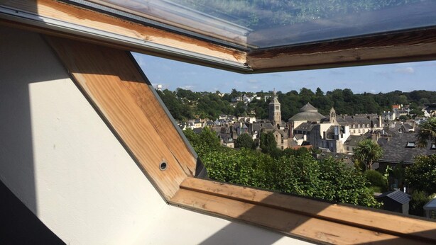 A skylight window with a view of a town featuring historic buildings and a church. - Agréable Appartement sur les Hauteurs de Quimperlé (Quimperlé)