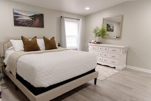 A bedroom with a bed, a dresser, a mirror, and a window with curtains. - Country Outback Cozy Home *W/Camp Fire Pit* (Parkesburg)