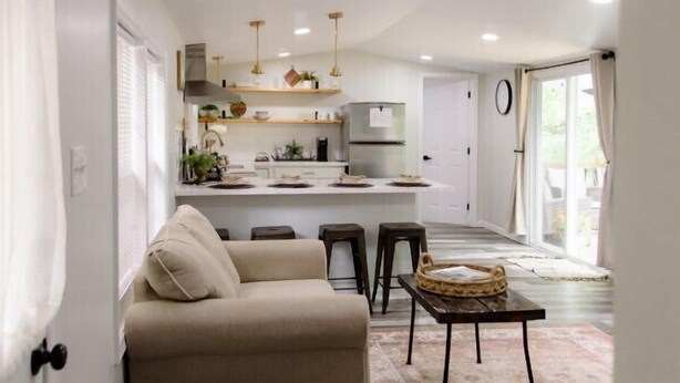 A modern interior with a sofa, a coffee table, and a kitchen area with a dining set.