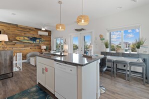 A modern kitchen with a wooden accent wall, a large island, and a view of the outdoors.
