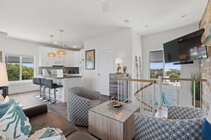 A modern living room with a sofa, a coffee table, and a TV mounted on the wall.