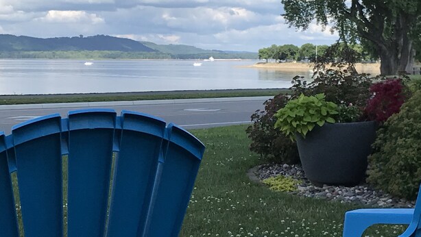 A view of a lake with a chair and a planter in the foreground. - Beautiful spacious house with spectacular  views of Lake Pepin (Lake City)