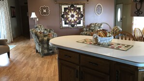 A dining area with a central island, patterned chairs, and a decorative wall piece. - Beautiful spacious house with spectacular  views of Lake Pepin (Lake City)