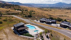 A residential area with a swimming pool, a road, and houses with dark roofs. - 3 Ski Resorts, Hiking, 2 King Bds, Private Hot Tub (Eden)