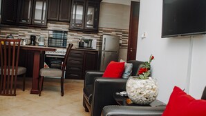 A modern kitchen with dark wooden cabinets, a built-in microwave, and a stainless steel refrigerator.