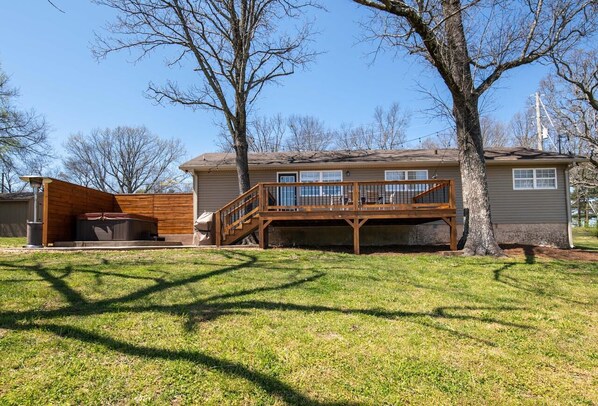 A two-story house with a wooden deck and a covered outdoor area.