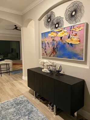 Relax in a serene space with a large abstract painting, console table, and floor lamp.