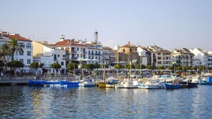A marina with boats docked, surrounded by multi-story buildings with balconies and a clear sky. - Villa Jardin by Interhome (Cambrils)