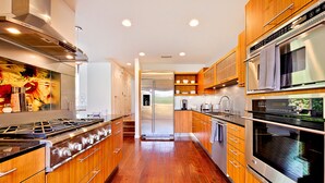 Une cuisine moderne avec des meubles en bois, des appareils en acier inoxydable et un îlot central.