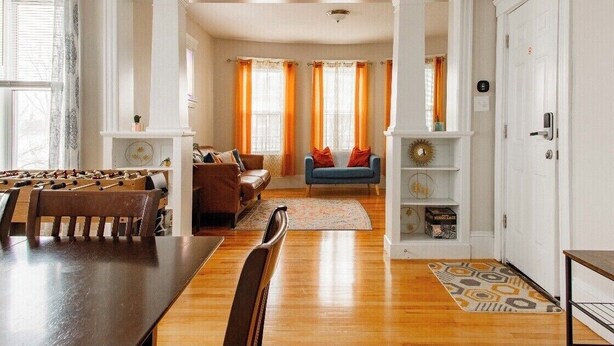 A spacious living room with a wooden dining table, sofas, and a blue armchair. - Large 3BR APT w/ enclosed front porch Close to Polar Park, palladium, WPI, DCU  (Worcester)