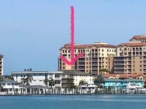 A beachfront hotel with multiple balconies, a marina, and a clear blue sky. - 4 BR Oasis, water views every room steps to beach! (Clearwater)