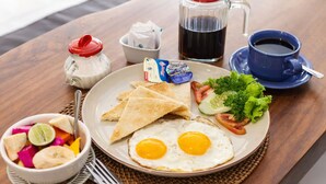 A breakfast plate with eggs, toast, salad, and a drink. - Naksa Homestay Sanur (Denpasar)