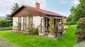 A small house with a red roof, a chimney, and a garden with potted plants and a barbecue area. - Vacation home Měřín by Interhome (Slapy)