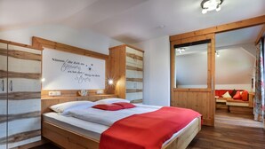 A bedroom with a wooden bed, a mirror, and a wall with a motivational quote.