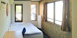 A room with a bed, a window with curtains, a radiator, and a wall-mounted hook. - Cote House (Osaka)