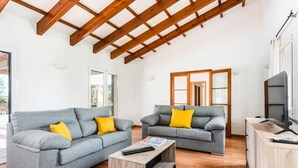 A spacious living area with two grey sofas, wooden coffee table, and a TV stand. - Villa Flomertor 2  (Ciutadella de Menorca)