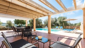 An outdoor patio with a pool, lounge chairs, and a table with chairs. - Villa Flomertor 2  (Ciutadella de Menorca)