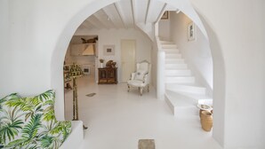 A white interior with a staircase, a chair, and a plant. - Asimina (Mykonos)
