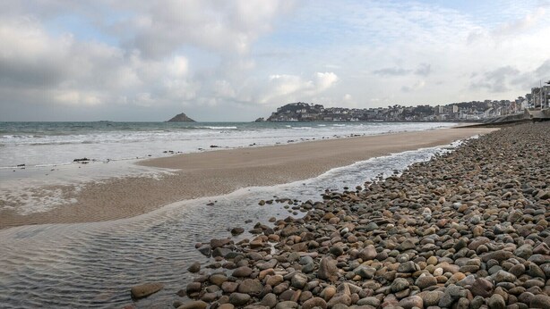 A rocky beach with a pebble path leading to the water, a sandy shore, and a distant view of buildings. - Flat for 4 by the sea in Pléneuf-Val-André (Pléneuf-Val-André)