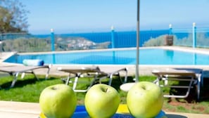 Une vue sur la piscine avec trois pommes vertes disposées sur un plateau.