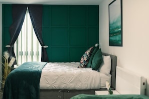 A bedroom with a bed, a radiator, a window with curtains, and a wall-mounted painting. - 2 bed 2 bath apartment in City Centre (Liverpool)