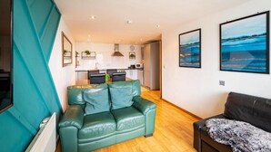 Leilighet – deluxe | Oppholdsområde | En 32-tommers Flatskjerm-TV med digitale kanaler samt TV