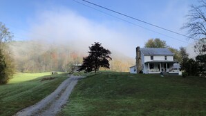 A house with a porch, a stone chimney, and a grassy yard. - Fulkerson-Hilton historic homestead (Hiltons)