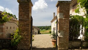 A rustic stone gate leading to a courtyard with a gravel path. - La Maison de Campagne - Le Farat (Auvillar)