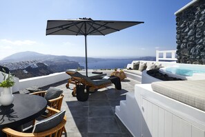 Une terrasse sur le toit avec une piscine, des chaises longues et une table agrémentée d’une plante en pot.