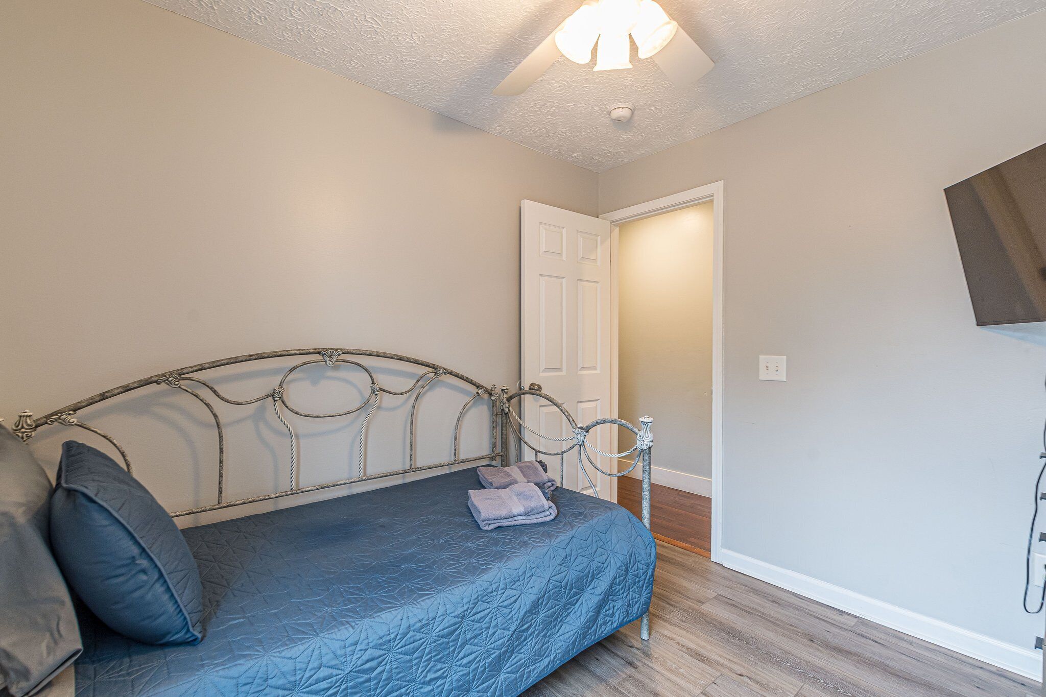 Une chambre à coucher avec un lit, des oreillers et un luminaire au plafond.