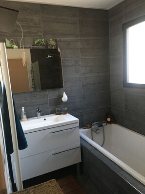 Bathtub, hair dryer, towels, toilet paper