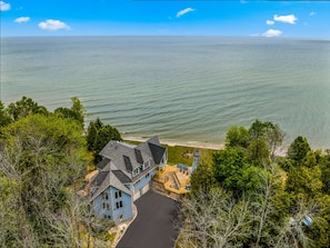 Une grande maison avec une allée et une vue sur la mer.