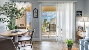Una sala de estar con comedor, un balcón con vistas y un sofá.