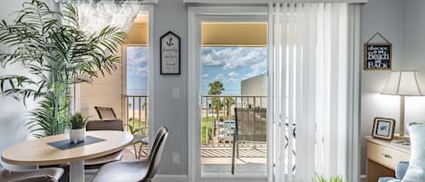 Una sala de estar con comedor, un balcón con vistas y un sofá.